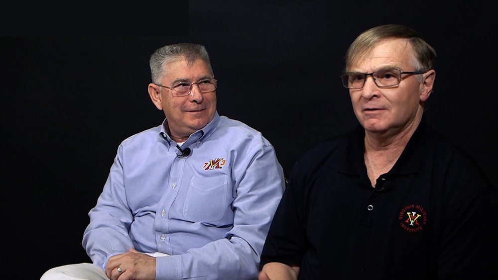 Mike Kelly '73 and Steve Kelly '77 mid-interview. They sit beside each other in front of a black background.