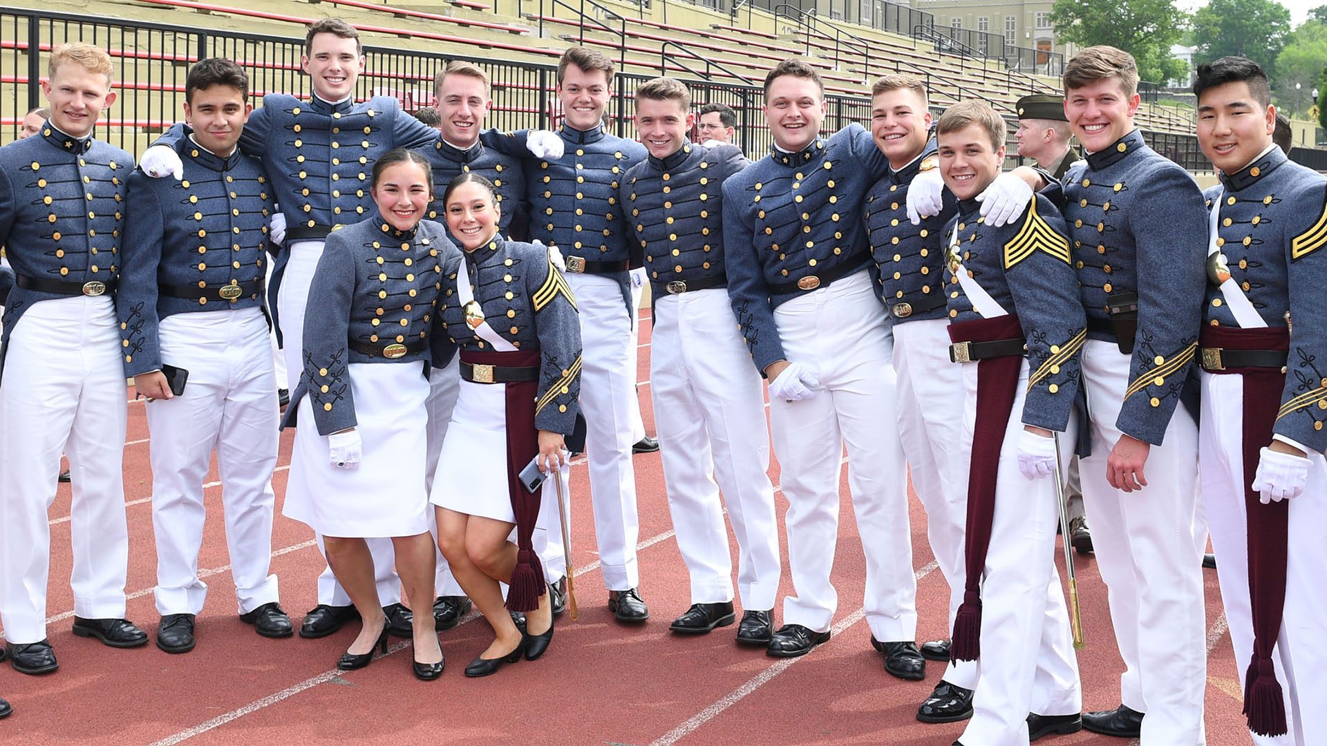 Group of cadets smiling on the football field before graduation
