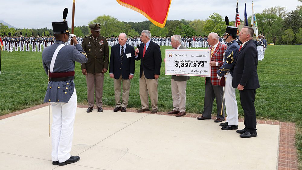 Maj. Gen. Cedric Wins '85 stands with members of the Class of 1974, who are holding a ceremonial check to VMI, totaling $8,891,974