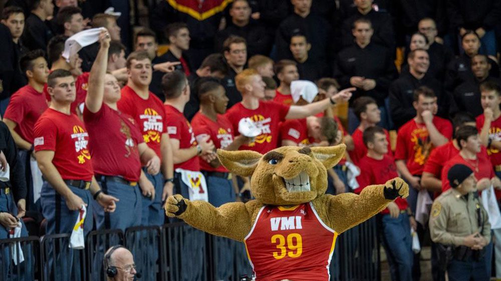 Moe the mascot with cheering fans behind him