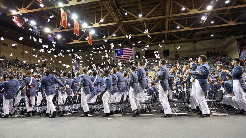 cadets throw gloves in the air in celebration at graduation in Cameron Hall