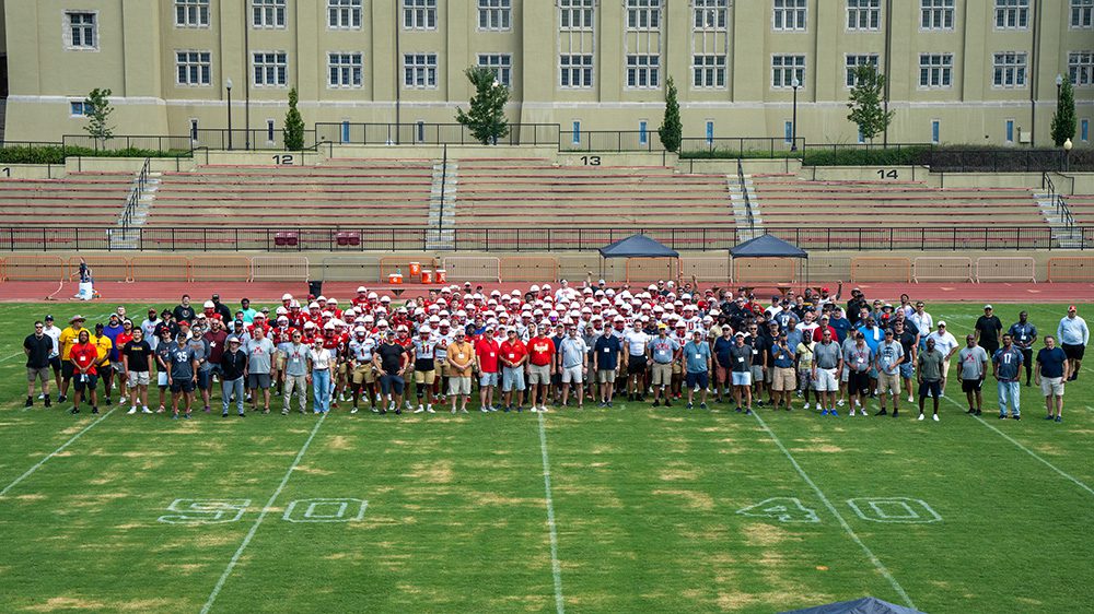 the VMI football team and football alumni gathered on the football field