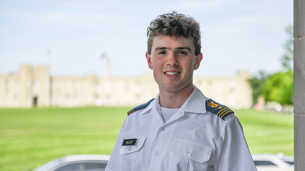 cadet in class dyke, barracks in background