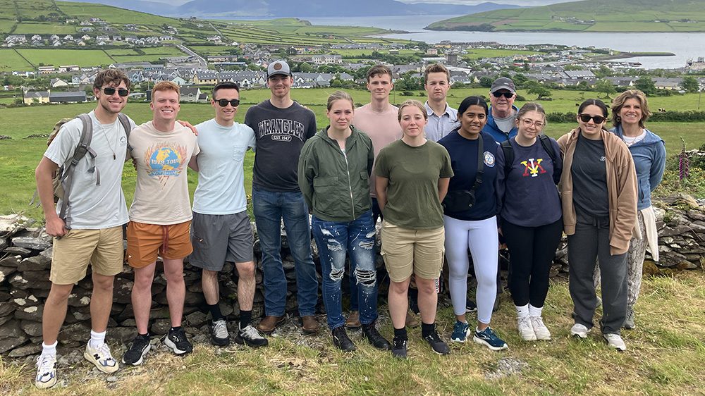 Group of students on study abroad trip to Ireland gathered with arms around each other, smiling